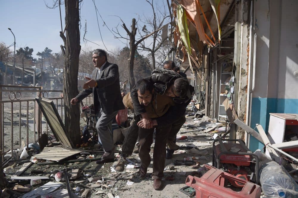 Afghan volunteers carry a body at the scene of a car bomb exploded in front of the old Ministry of Interior building in Kabul on Jan. 27, 2018. An ambulance packed with explosives blew up in a crowded area of Kabul on January 27, killing at least 17 people and wounding 110 others, officials said, in an attack claimed by the Taliban. (Wakil Kohsar/AFP/Getty Images)