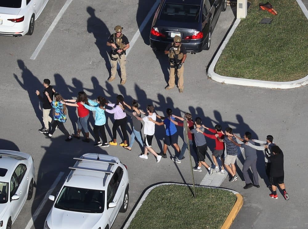 People are brought out of the Marjory Stoneman Douglas High School after a shooting on Feb. 14, 2018 in Parkland, Fla. President Trump's reference to the school resource officer who remained outside during the shooting as a &quot;coward&quot; sparked a national conversation about cowardice. (Joe Raedle/Getty Images)
