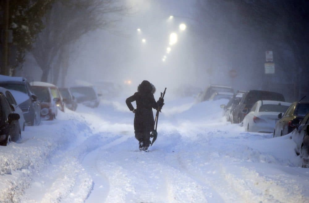 A woman walks down snow-covered Maverick Street in the East Boston neighborhood of Boston, Thursday, Jan. 4, 2018, as a huge winter storm roared up the East Coast with hurricane-force winds, heavy snow and coastal flooding. (Michael Dwyer/AP)