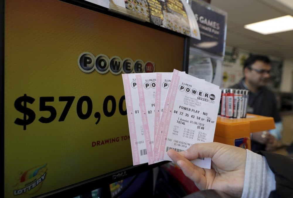 A customer shows her purchased Powerball tickets at a convenience store Saturday, Jan. 6, 2018, in Chicago. The jackpot jumps to an estimated $570 million for Saturday's drawing. That would make it the nation's 8th largest lottery prize ever. (AP Photo/Nam Y. Huh)