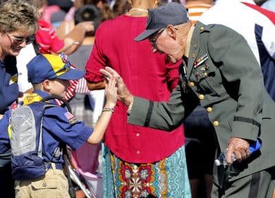 Cub Scout Carter Chase, 7, high fives WWII U.S. Army veteran Oliver Babbitts during a Veteran's Day parade, Monday, Nov. 11, 2013, in downtown Phoenix. (Matt York/AP)