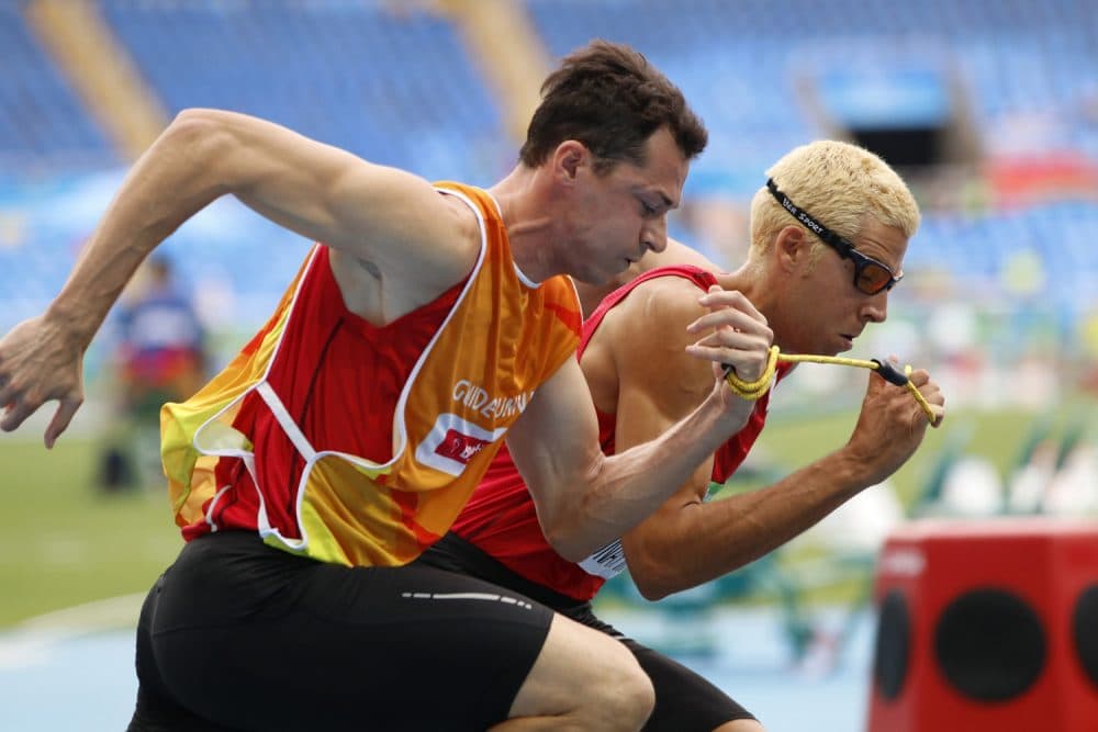 In this Thursday, Sept. 8, 2016 photo, Joan Lunar Martinez, right, of Spain and his guide Juan Enrique Valles Pastor compete in the men's 400-meter T12 first round, third heat at the 2016 Paralympic Games in Rio de Janeiro, Brazil, on. During the summer Paralympics, guides are used in cycling, equestrian, five-a-side soccer, triathlon and track and field events. (David A. Barnes/University of Georgia via AP)