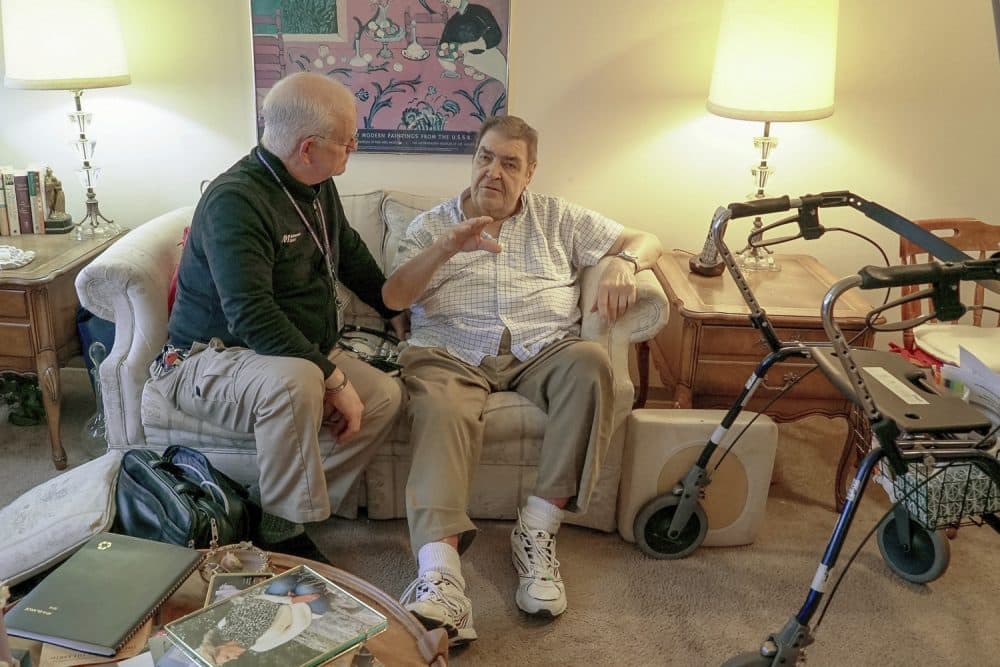 Nurse practitioner Dwayne Dobschuetz, left, visits patient Marvin Shimp, at Shimp's home in Chicago on Jan. 10, 2018. Shimp has lost much of his vision to macular degeneration and Dobschuetz's house calls help him stay out of the hospital with regular visits to check vitals and answer questions. Dobschuetz sees several patients in their homes each day, traveling by bicycle. He works at Northwestern Medicine in Chicago, which is taking a new approach to helping older patients stay healthier. (AP Photo/Teresa Crawford)