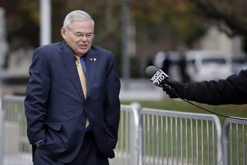U.S. Sen. Bob Menendez, center, shrugs as a reporter asks him questions while leaving the Martin Luther King Jr. Federal Courthouse after stopping in to appear on his corruption trial, Tuesday, Nov. 14, 2017, in Newark, N.J. Jury deliberations in the bribery trial of Menendez continued Tuesday. (AP Photo/Julio Cortez)