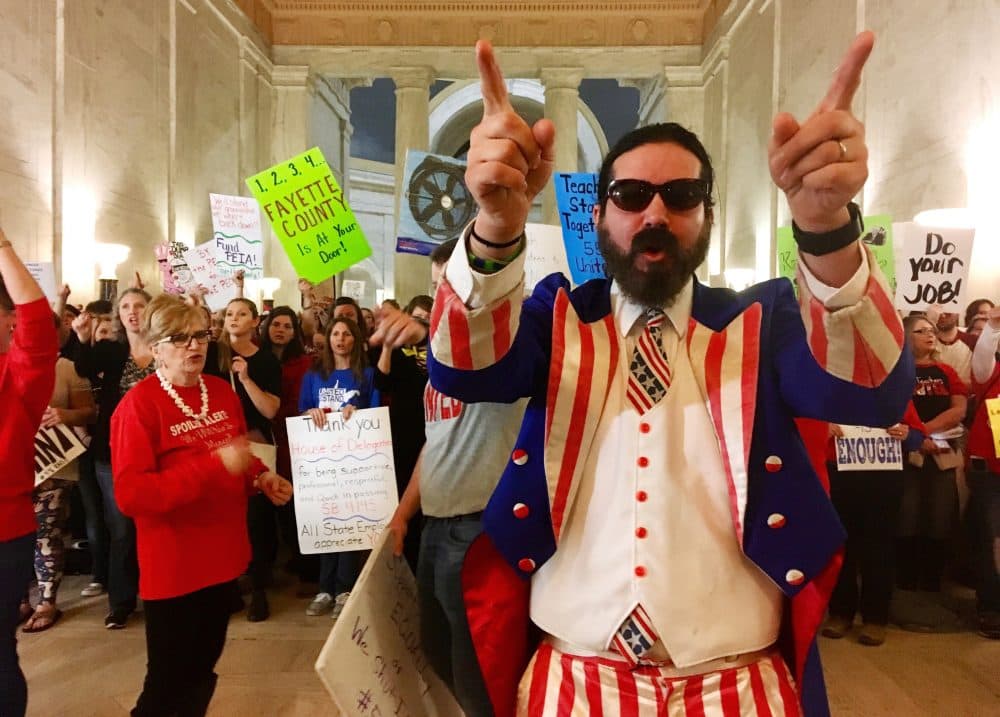 Parry Casto, a fifth grade teacher at the Explorer Academy in Huntington, W.Va., dressed in an Uncle Sam costume leads hundreds of teachers in chants outside the state Senate chambers at the Capitol in Charleston, W.Va., Thursday, March 1, 2018. Teachers were awaiting a Senate vote on a proposed 5 percent pay increase for them. (John Raby/AP)