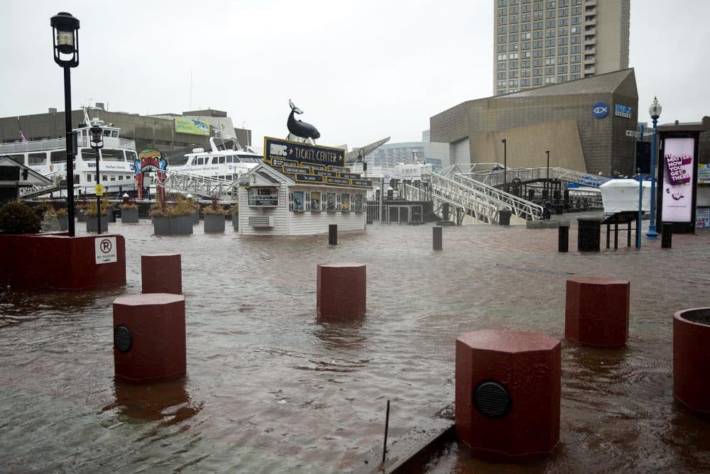 The Boston Harbor Cruises ticket office stands completely surrounded by water as high tide floods Long Wharf. (Robin Lubbock/WBUR)