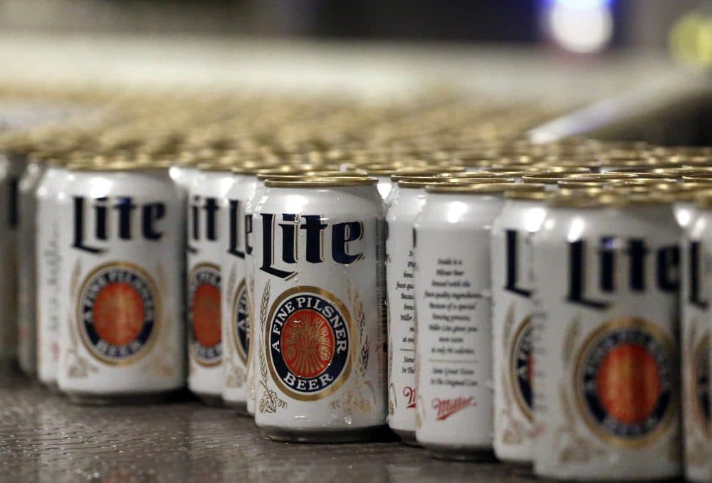 In this March 11, 2015 photo, newly filled and sealed cans of Miller Lite beer move along on a conveyor belt, at the MillerCoors Brewery, in Golden, Colo. (Brennan Linsley/AP)