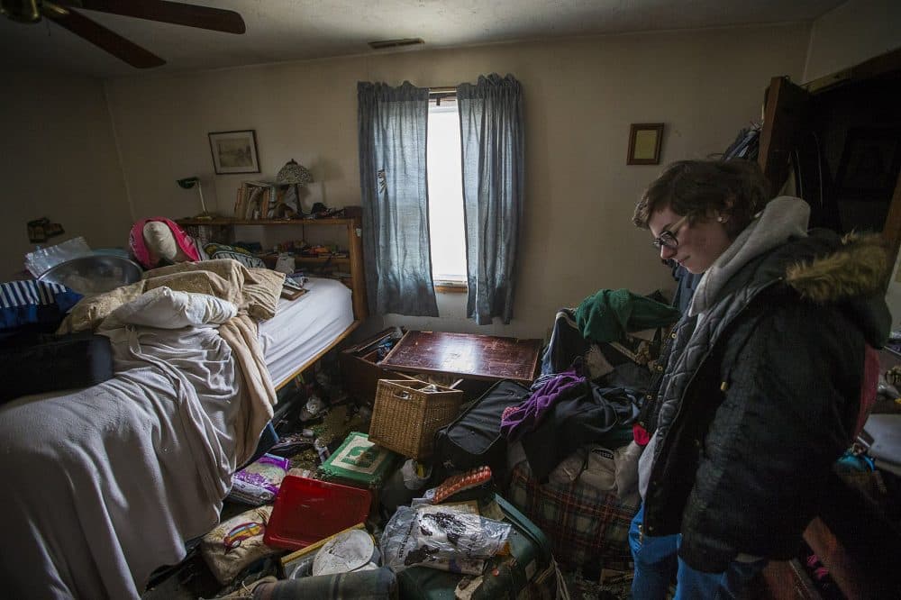 Taylor Fenton bows her head, looking at the damage in one of the family bedrooms in her home in Quincy caused by the nor'easter on Friday. (Jesse Costa/WBUR)