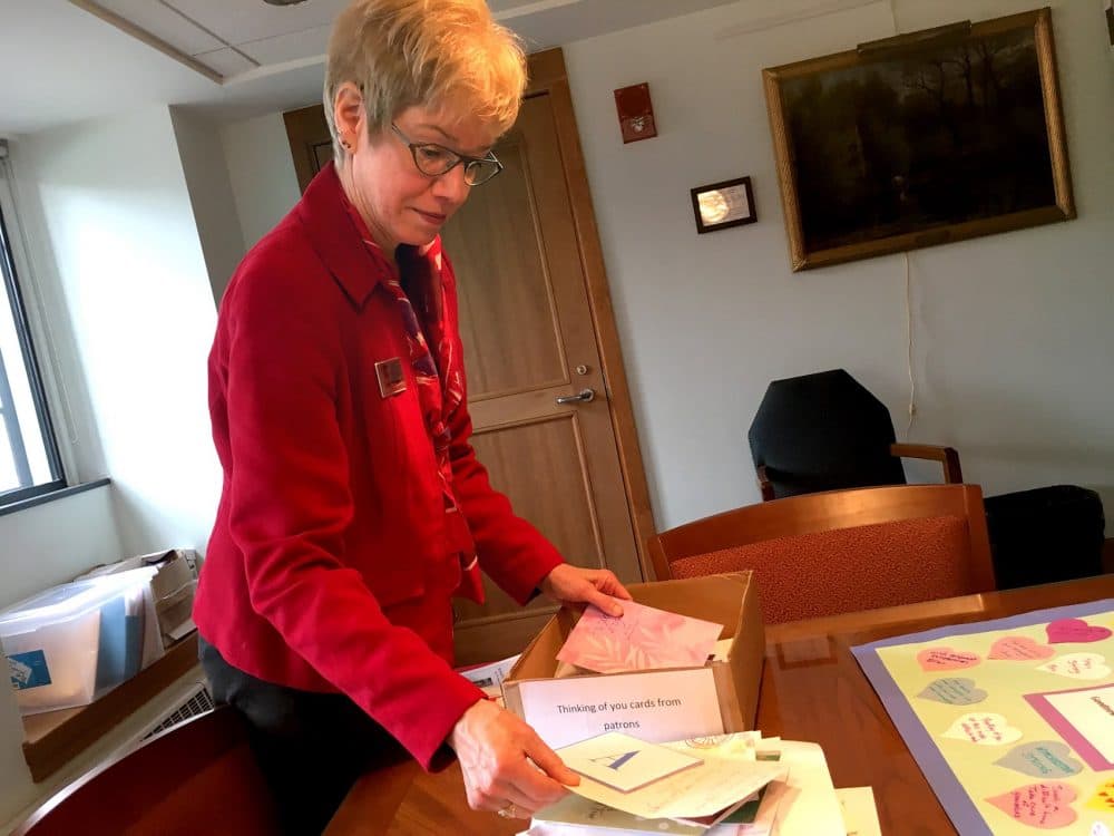 Ann Wirtanen, Director of Winchester Public Library, holds the letters that have come from community members and libraries across the country. (Yasmin Amer/WBUR)