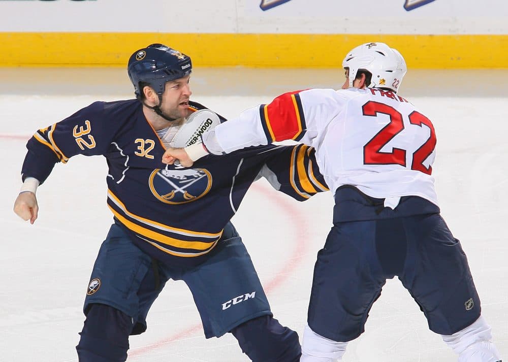 John Scott, left, made a name in the NHL brawling. But that's not his whole story. (Rick Stewart/Getty Images)