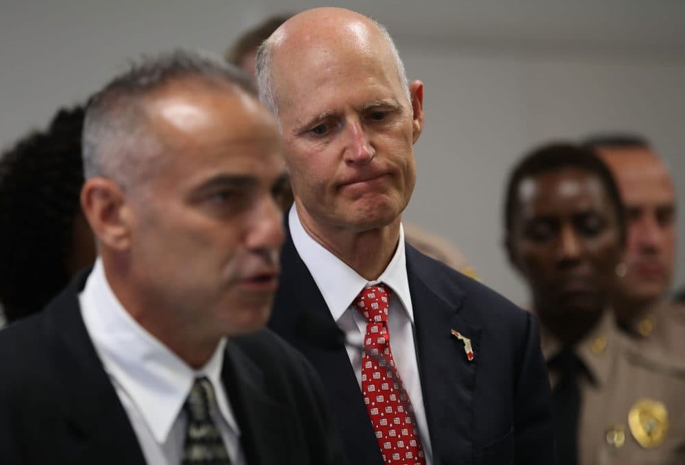 Florida Gov. Rick Scott listens as Andy Pollack, who lost his daughter Meadow Pollack, 18, during the mass shooting at Marjory Stoneman Douglas High School, speaks during a press conference at Miami-Dade police headquarters on Feb. 27, 2018 in Doral, Fla. (Joe Raedle/Getty Images)