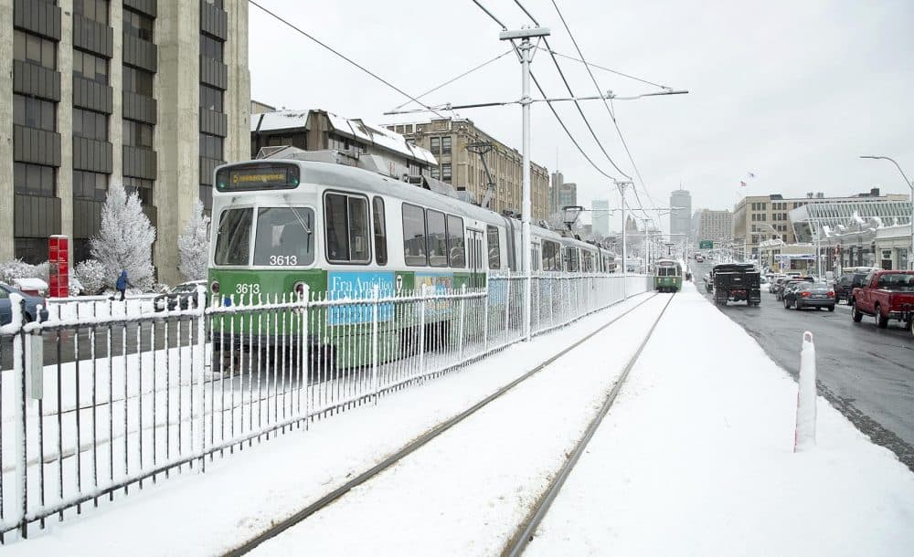 MBTA Green Line trains run along snow-covered lines in Boston after overnight snow. (Robin Lubbock/WBUR)