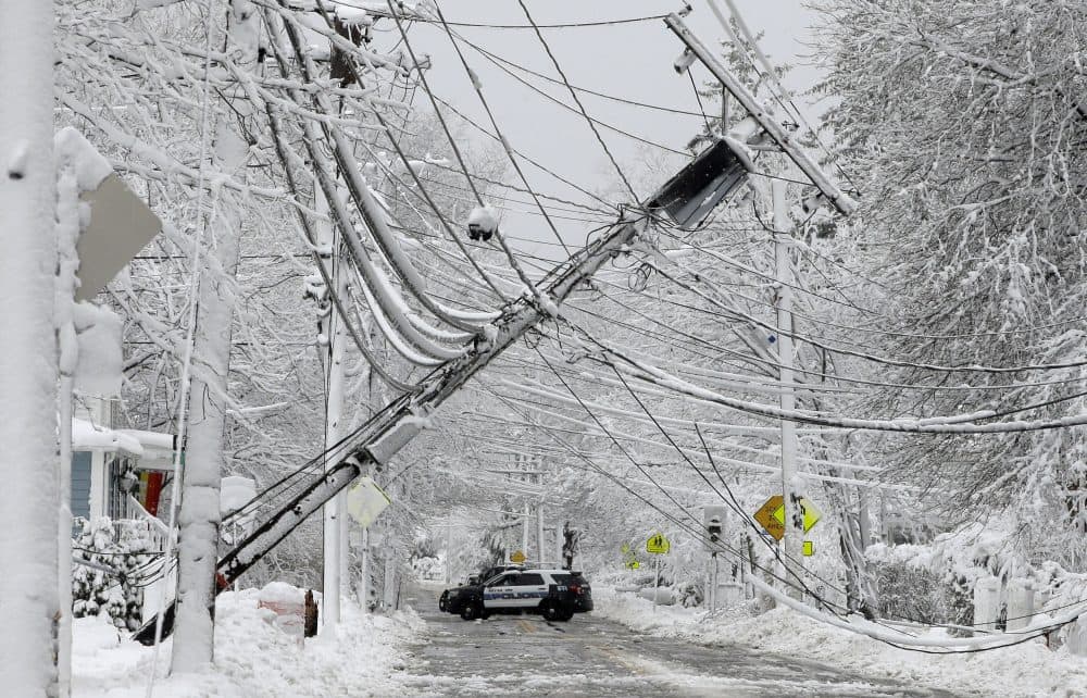 A police vehicle blocks a road near downed power lines on March 8 in Natick, Mass. (Steven Senne/AP)
