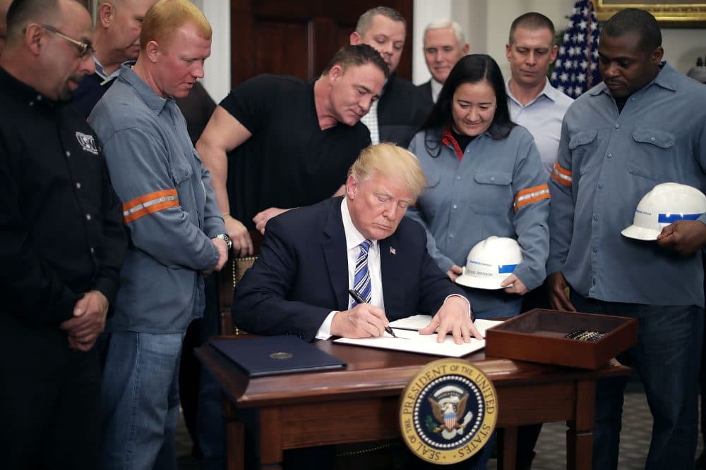 Surrounded by steel and aluminum workers, President Trump (center) signs a proclamation on steel imports during a ceremony in the Roosevelt Room at the White House on March 8, 2018 in Washington, D.C. (Chip Somodevilla/Getty Images)