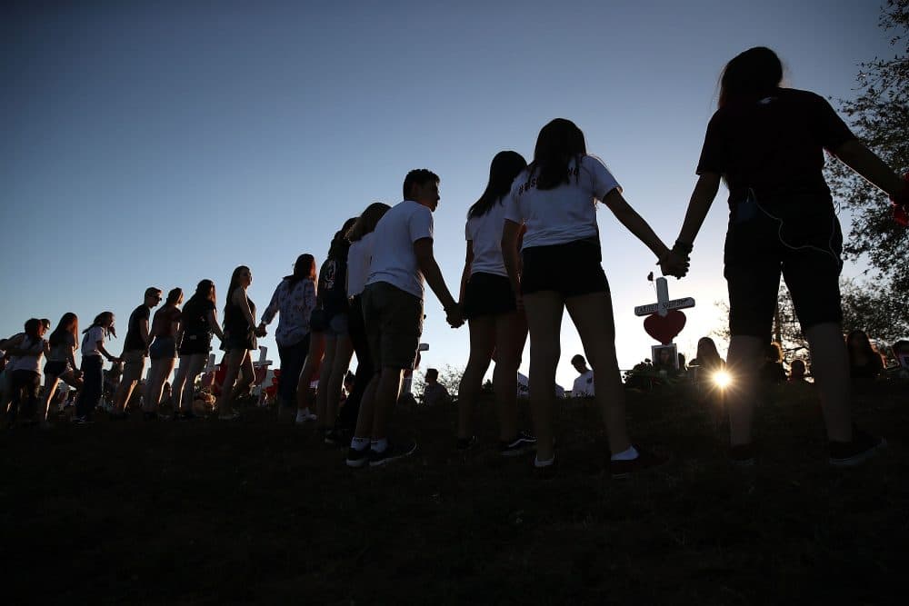 Students and family members holds hands around a makeshift memorial in front of Marjory Stoneman Douglas High School on Feb. 18, 2018 in Parkland, Fla. (Mark Wilson/Getty Images)