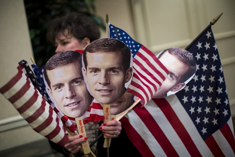 A supporter carries flags and photos of Conor Lamb at an election night event for Lamb, Democratic congressional candidate for Pennsylvania's 18th district, on March 13, 2018 in Canonsburg, Pa. (Drew Angerer/Getty Images)