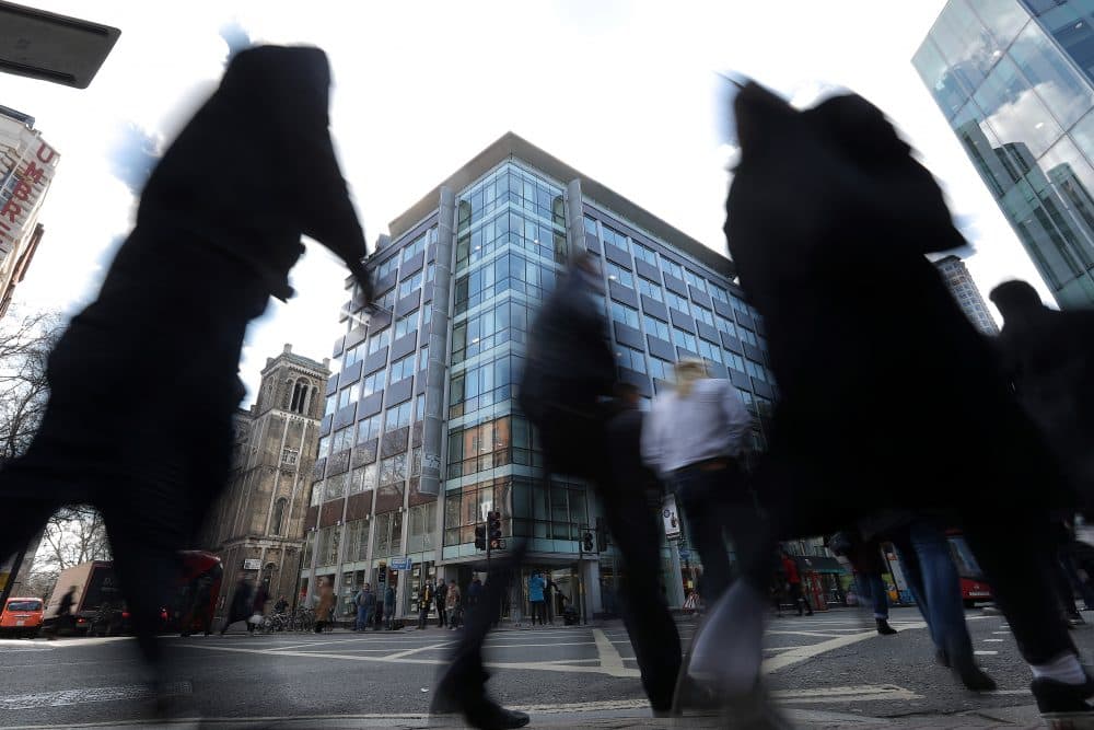 Pedestrians pass the shared building which houses the offices of Cambridge Analytica in central London on March 21, 2018. Facebook expressed outrage Tuesday over the misuse of its data as Cambridge Analytica, the British firm at the center of a major scandal rocking the social media giant, suspended its chief executive. (Daniel Leal-Olivas/AFP/Getty Images)