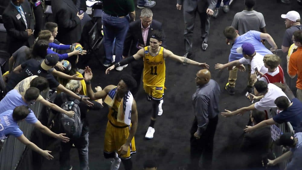 UMBC's K.J. Maura (11) greets fans as he leaves the court after the team's second-round game against Kansas State in the NCAA men's college basketball tournament in Charlotte, N.C., Sunday. Kansas State won 50-43. (Chuck Burton/AP)