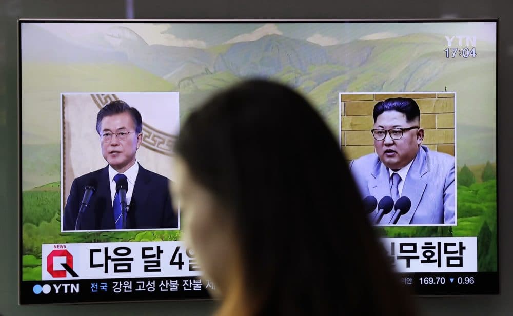A visitor walks by a TV screen showing file footages of South Korean President Moon Jae-in, left, and North Korean leader Kim Jong Un, right, during a news program at the Seoul Railway Station in Seoul, South Korea, Thursday, March 29, 2018. North Korean leader Kim will meet South Korean President Moon at a border village on April 27, the South announced Thursday after the nations agreed on a rare summit that could prove significant in global efforts to resolve a decades-long standoff over the North's nuclear program. (Lee Jin-man/AP)