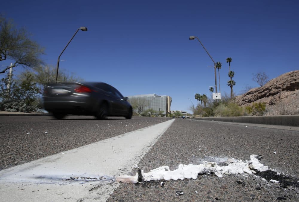 A vehicle goes by the scene of Sunday's fatality where a pedestrian was stuck by an Uber vehicle in autonomous mode, in Tempe, Ariz., Monday, March 19, 2018. (Chris Carlson/AP)