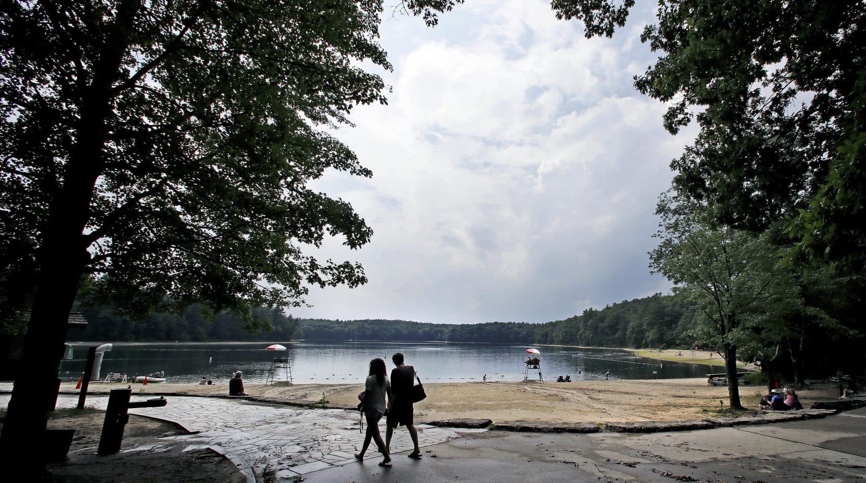A couple walks along the shore of Walden Pond in Concord, Mass. in 2017. (Charles Krupa/AP)