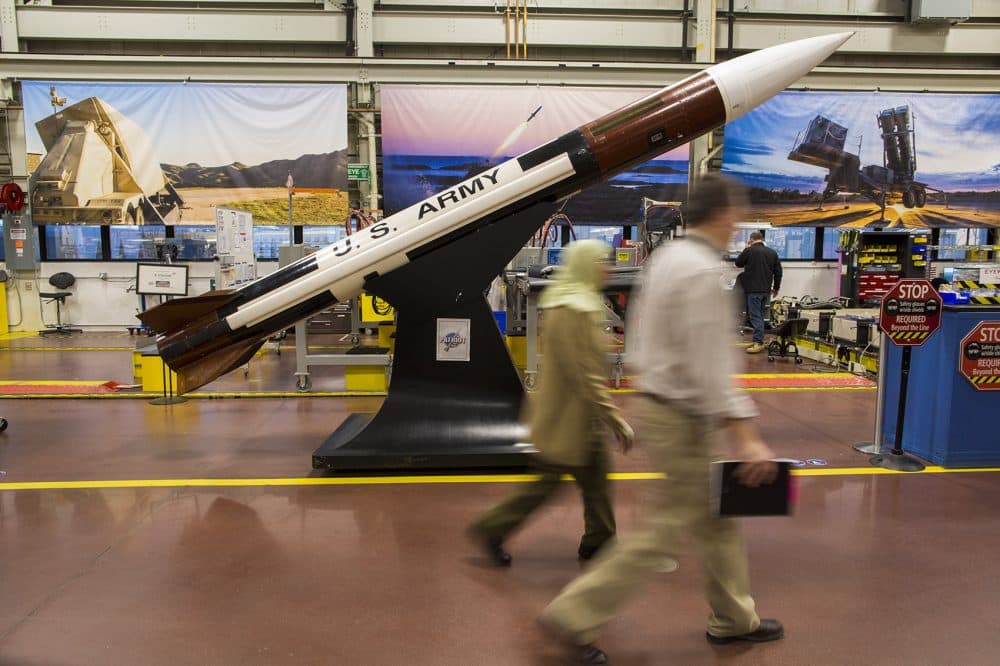 Two Raytheon employees walk past a mock-up of a Patriot missile at the company's Andover facility. Raytheon is the largest producer of guided missiles in the world. (Jesse Costa/WBUR)