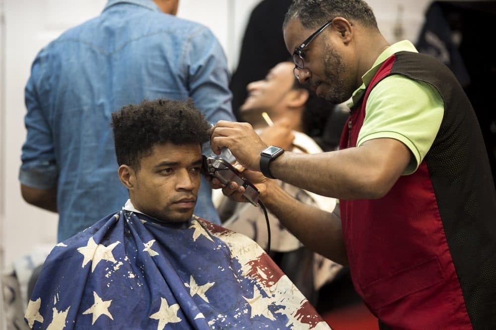 A haircut and a shave being given at Johnny's Barbershop on Bowdoin Street in Dorchester. (Jesse Costa/WBUR)