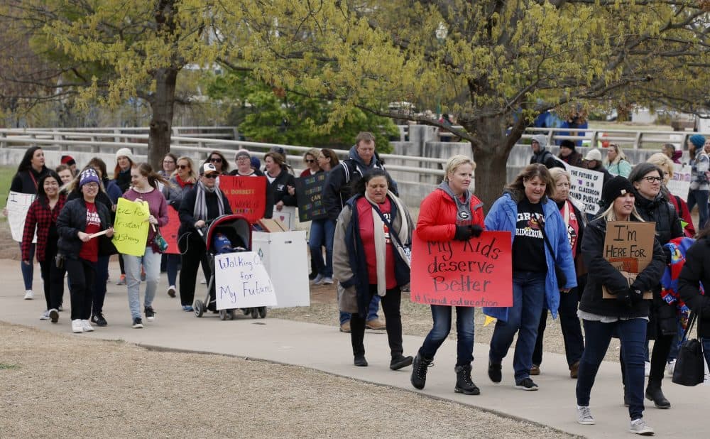 Supporters carry signs as they picket around the state Capitol during a teacher's rally in Oklahoma City, Monday, April 2, 2018. Teachers were holding separate protests in Oklahoma and Kentucky on Monday to voice dissatisfaction with issues like pay and pensions. (AP Photo/Sue Ogrocki)