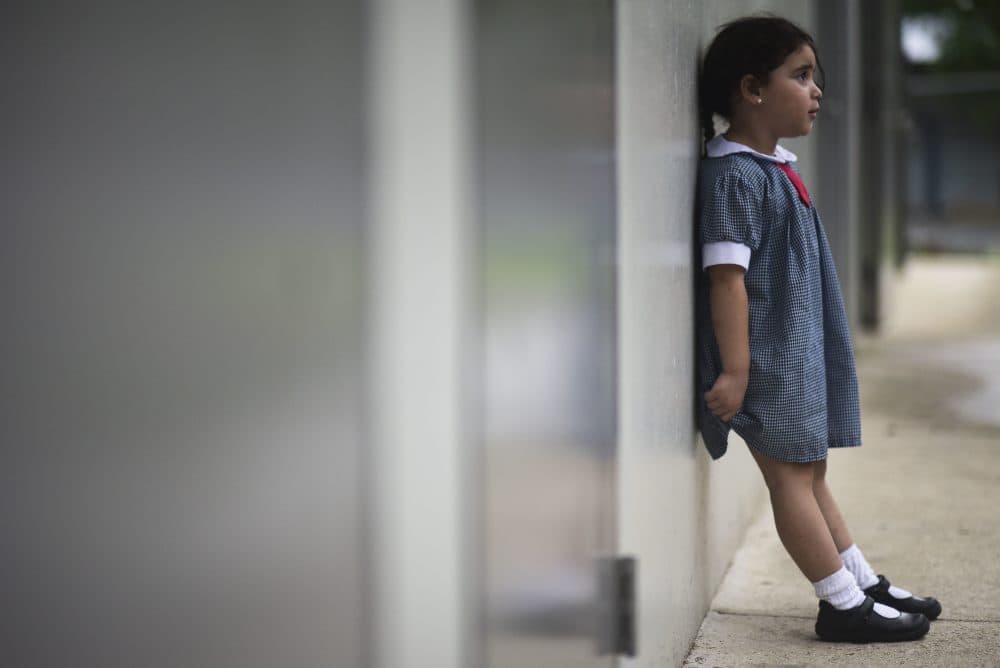 In this Friday, Oct. 13, 2017 photo, a girl waits for her mother in the hallway of Ramon Marin Sola Elementary School, which opened its doors as a daytime community center after the passing of Hurricane Maria in Guaynabo, Puerto Rico. (Carlos Giusti/AP)