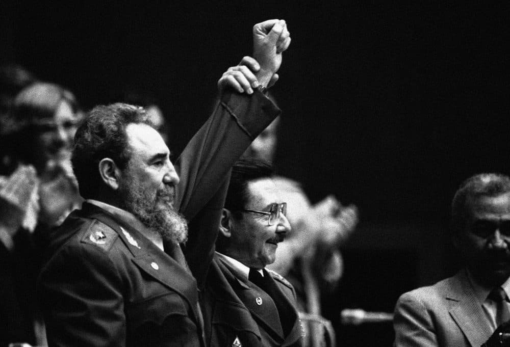 In this Feb. 8, 1986 file photo, Cuban President Fidel Castro, left, joins hands with his younger brother Raul Castro, chief of the Cuban Armed Forces and first vice president, after the two were reelected in the Third Cuban Communist Party Congress session in Havana, Cuba. (AP Photo/Charles Tasnadi, File)