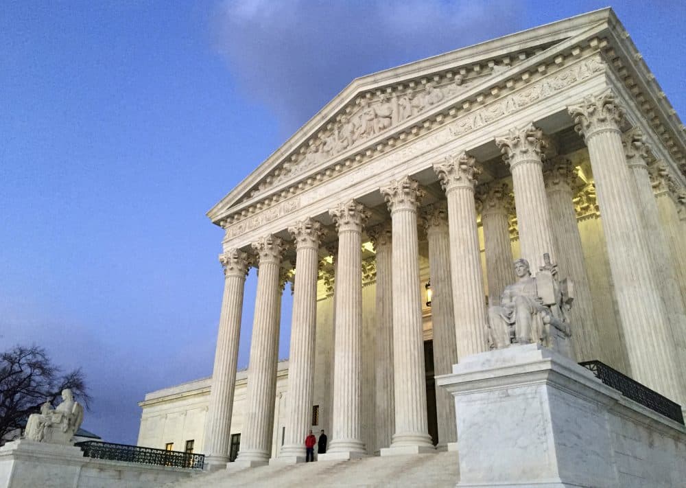 People stand on the steps of the Supreme Court at sunset in Washington in 2016. (Jon Elswick/AP)