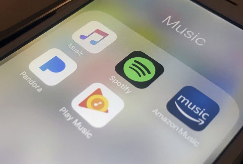This Sunday, Jan. 28, 2018, photo shows music streaming apps clockwise from top left, Apple, Spotify, Amazon, Pandora and Google on an iPhone in New York. (Jenny Kane/AP)