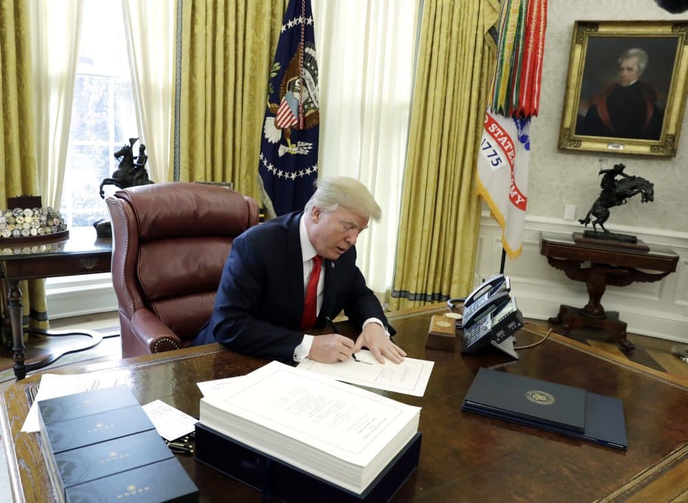President Trump signs into law a $1.5 trillion tax overhaul package on Dec. 22, 2017. (Evan Vucci/AP)