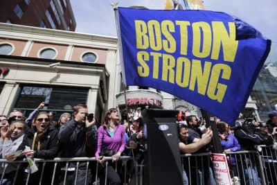 Race fans with a &quot;Boston Strong&quot; flag cheer for competitors near the finish line of the 118th Boston Marathon, Monday, April 21, 2014, in Boston. (Robert F. Bukaty/AP)