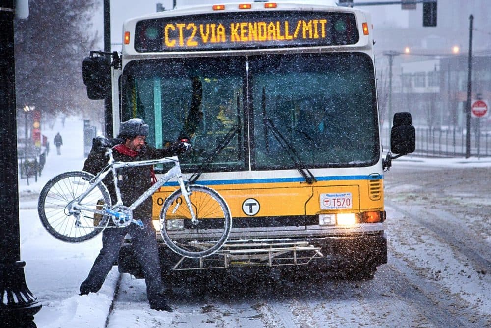 A commuter puts his bike on the front of an MBTA bus. (Jesse Costa/WBUR)