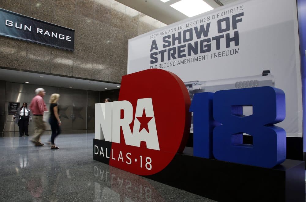 People walk by NRA convention signage in the Kay Bailey Hutchison Convention Center in Dallas, Thursday, May 3, 2018. The convention is scheduled to go through Sunday. (Sue Ogrocki/AP)