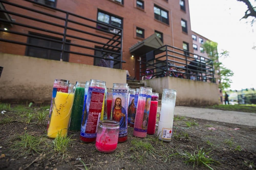 Candles sit in front of the Mildred C. Hailey Apartments where the May 4 shooting deaths of Christopher Joyce and Clayborn Blair occurred. (Jesse Costa/WBUR)