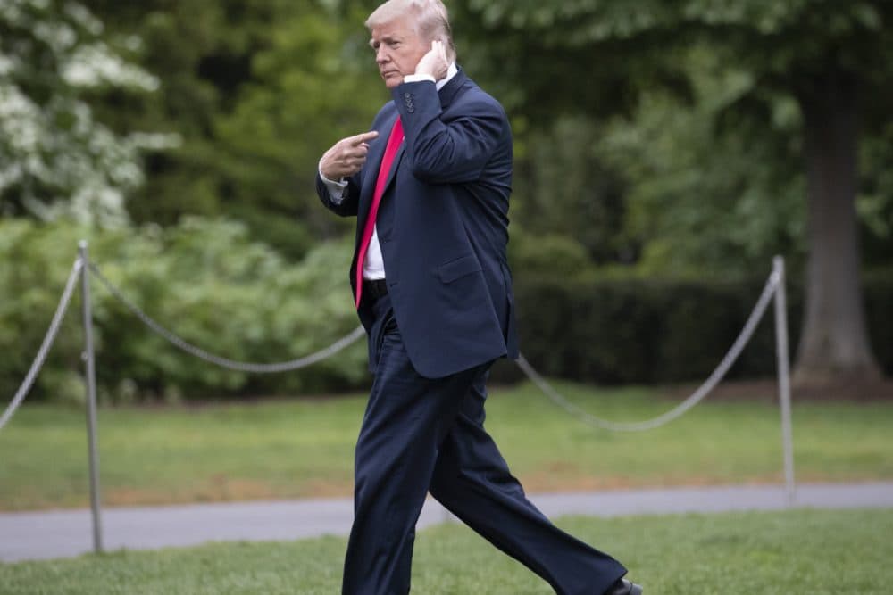 President Donald Trump signals to beckoning reporters that he can't hear them over the sound of his helicopter as he returns to the White House after speaking Cleveland to tout the Republican tax cuts just ahead of Ohio's primary election Tuesday, in Washington, Saturday, May 5, 2018. (J. Scott Applewhite/AP)