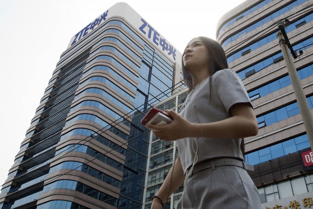 In this May 8, 2018, photo, a woman passes by a ZTE building in Beijing, China. (Ng Han Guan/AP)