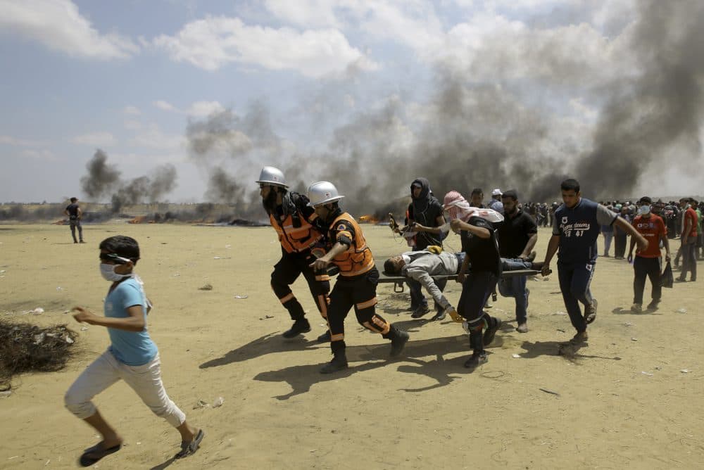 In this Monday, May 14, 2018 file photo, Palestinian medics and protesters evacuate a wounded youth during a protest at the Gaza Strip's border with Israel, east of Khan Younis, Gaza Strip. (Adel Hana/AP)