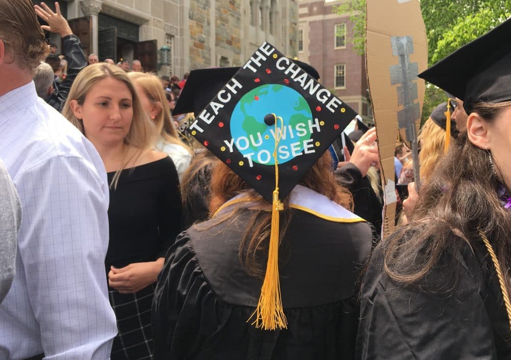 A freshly-graduated Wheelock College alumnae stands outside following the school's final undergraduate commencement. (Lisa Creamer/WBUR)
