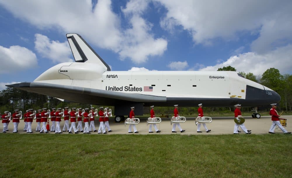 In this handout provided by NASA, U.S. Marine Corp Drum and Bugle Corps and Color Guard march past the space shuttle Enterprise, seen as the at the Steven F. Udvar-Hazy Center April 19, 2012, in Chantilly, Virginia. (Carla Cioffi/NASA via Getty Images)