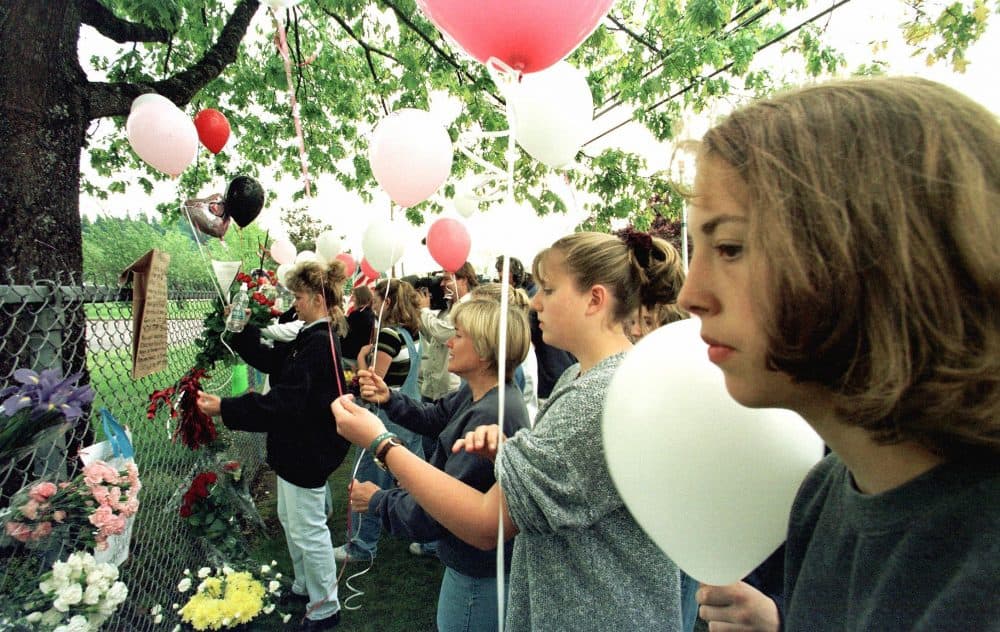 Residents of Springfield, Ore., gather near the fence of Thurston High School on May 22, 1998, to pay respect to those who died in the previous day's shooting in the school's cafeteria. (Hector Mata/AFP/Getty Images)