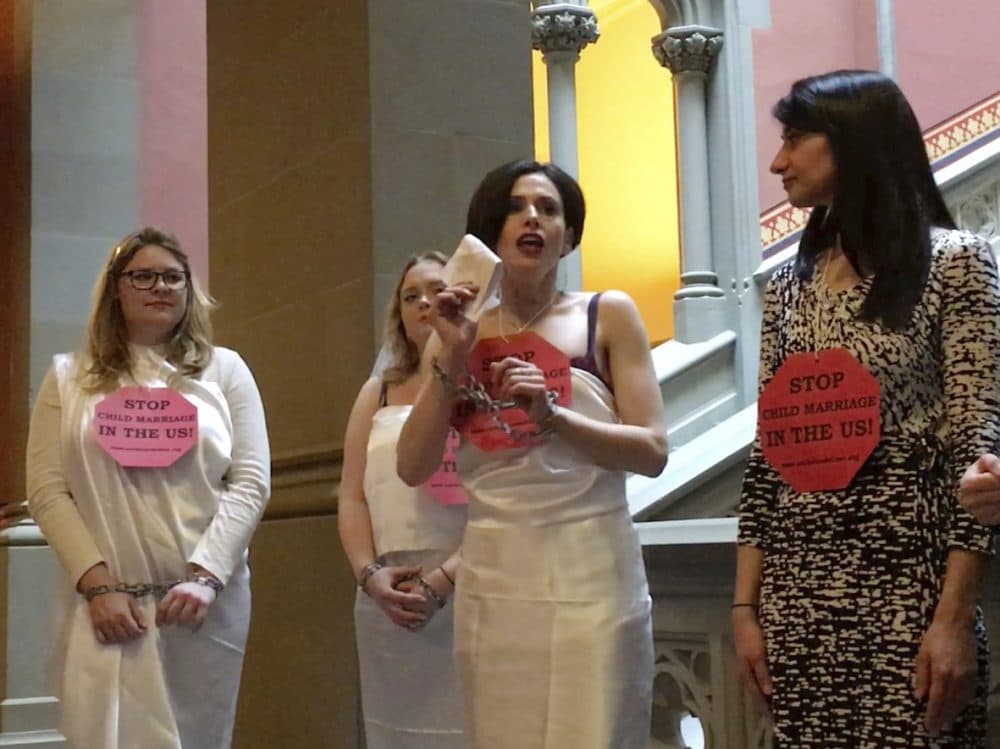 In this image taken from video, Fraidy Reiss, center, founder and executive director of Unchained at Last, a non-profit organization with the goal to end child marriages, demonstrates in chains at the State Capitol in Albany, N.Y., Tuesday, Feb. 14, 2017. (Anna Gronewold/AP)