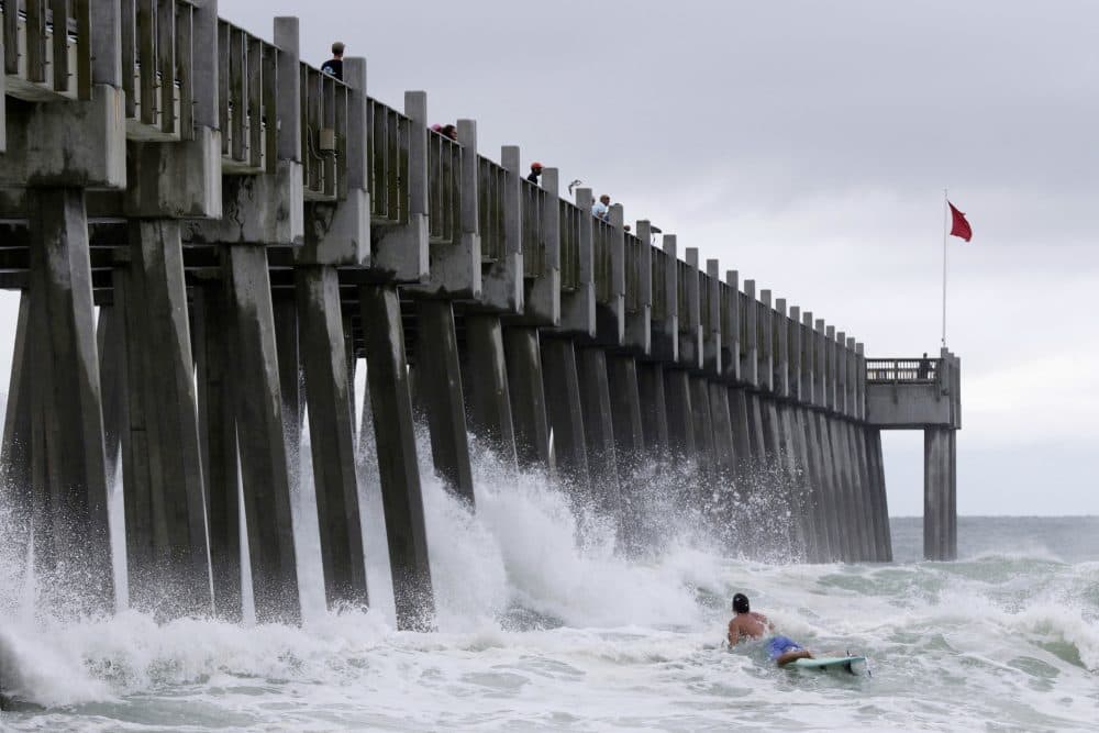 A surfer makes his way out into the water as a subtropical approaches on Monday, May 28, 2018, in Pensacola, Fla. The storm gained the early jump on the 2018 hurricane season as it headed toward anticipated landfall sometime Monday on the northern Gulf Coast, where white sandy beaches emptied of their usual Memorial Day crowds. (Dan Anderson/AP)
