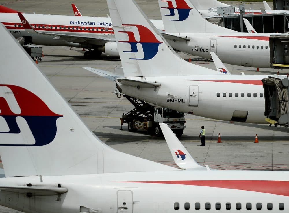 Malaysia Airlines ground staff walk past Malaysia Airlines aircraft parked on the tarmac at the Kuala Lumpur International Airport in Sepang in 2016. (Manan Vatsyayana/AFP/Getty Images)