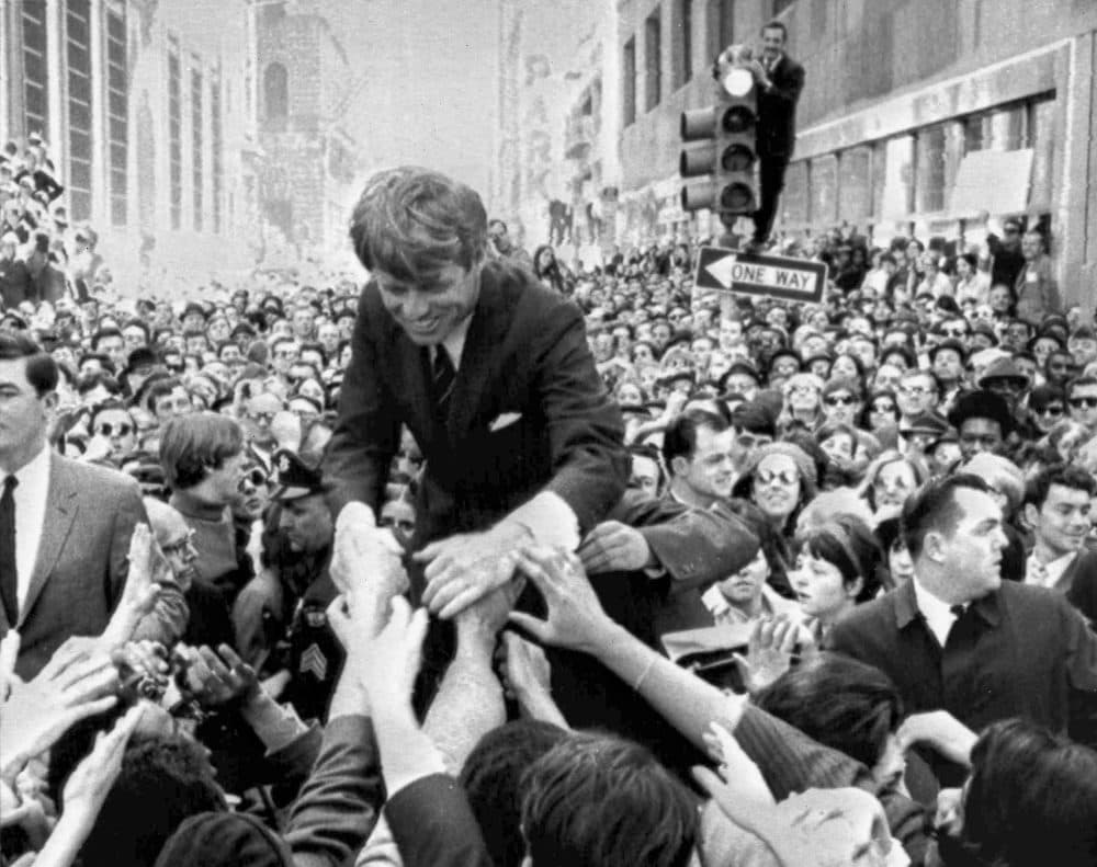 In this April 2, 1968 file photo U.S. Sen. Robert F. Kennedy, D-NY, shakes hands with people in a crowd while campaigning for the Democratic party's presidential nomination on a street corner, in Philadelphia. (Warren Winterbottom/AP)