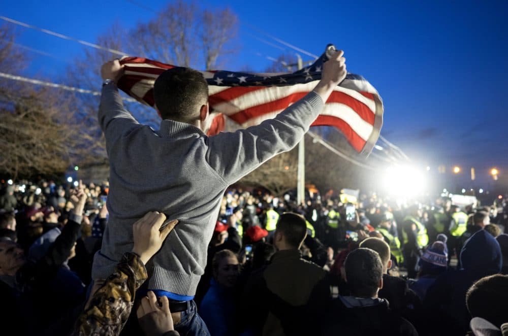 A Donald Trump supporter is hoisted up holding an American flag as the group faced off with Trump protesters about 50 feet away, near the site of a campaign appearance by the Republican presidential candidate in Bethpage, New York, Wednesday, April 6, 2016. (Craig Ruttle/AP)