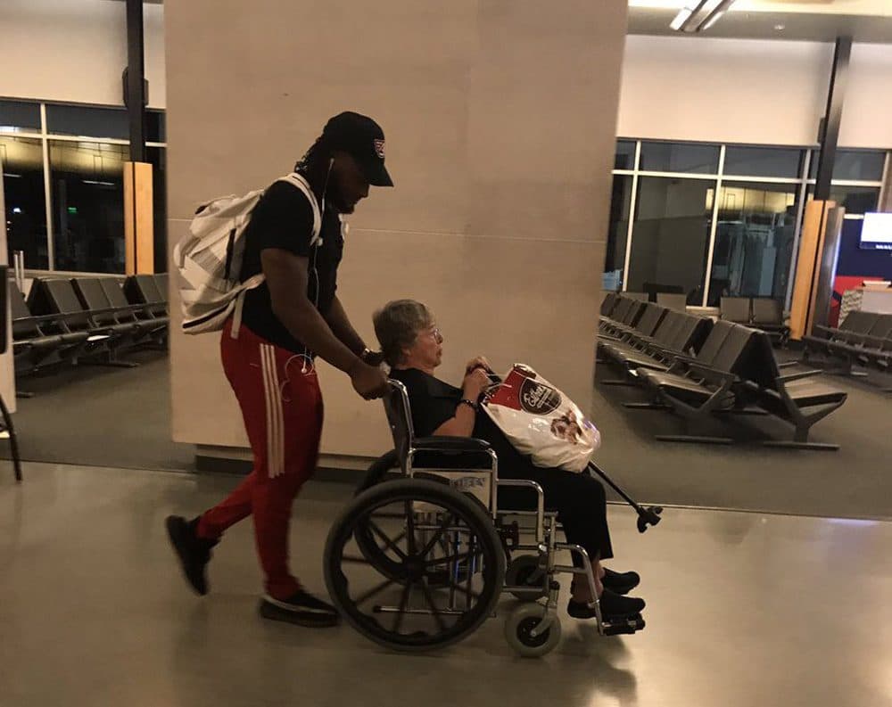 Green Bay Packers running back Aaron Jones wheels an airline passenger through Appleton International Airport after the airline failed to provide that service for her. (Courtesy Monica Allen via Twitter)