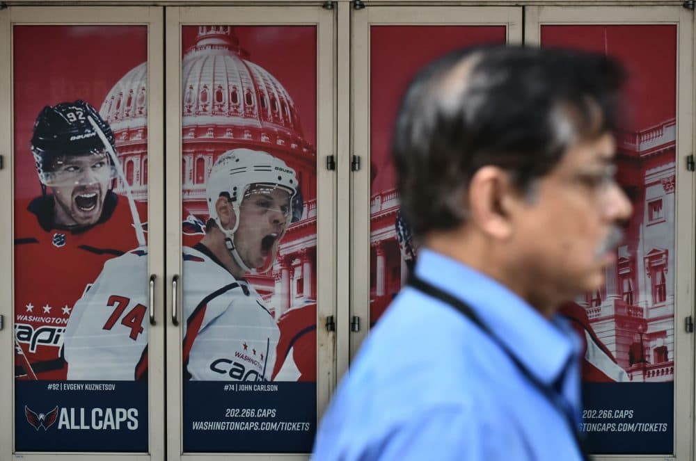 A pedestrian passes by a poster outside of the Capital One Arena on June 5, 2018 in Washington, D.C., as the Washington Capitals head into game 5 of the Stanley Cup against the Vegas Golden Knights. (Mandel Ngan/AFP/Getty Images)